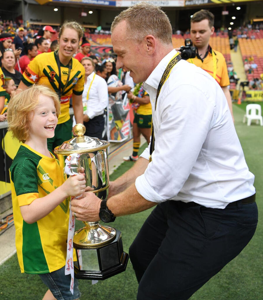 Brad Donald handing a trophy to a young fan on the field